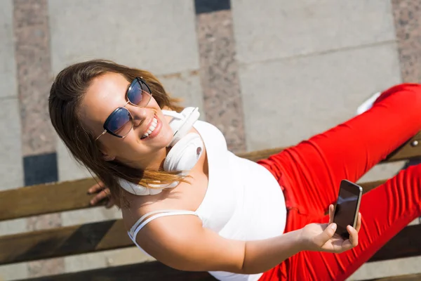 Žena sedí s mobilním telefonem — Stock fotografie