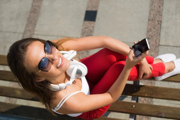 Kvinna sitter med mobiltelefon — Stockfoto