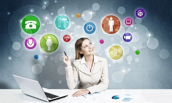 Businesswoman at workplace and media icons — Stock Photo, Image