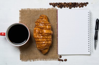 Not defteri ve kruvasan ile kahve