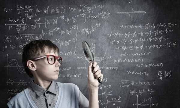 Netter Junge, der durch Vergrößerungsglas schaut — Stockfoto