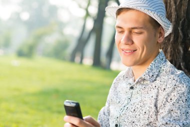 Cep telefonu olan genç bir adam.