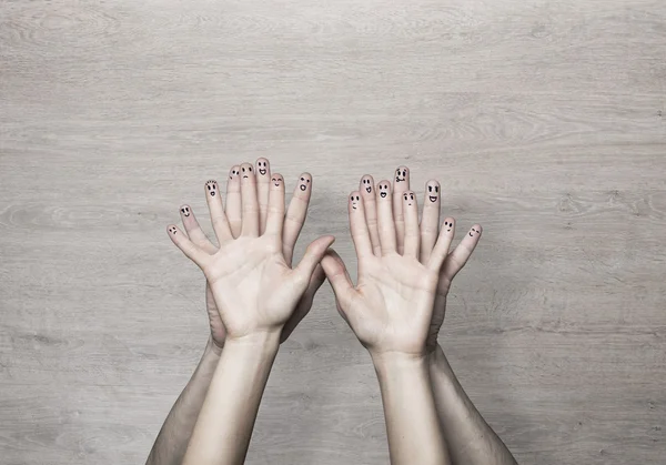 Mani con le facce sulle dita — Foto Stock