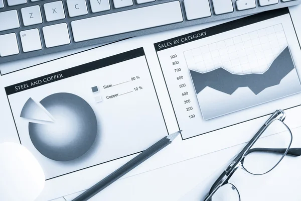 Lugar de trabajo con teclado y diagramas —  Fotos de Stock