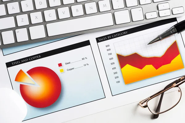 Lugar de trabajo con teclado y diagramas — Foto de Stock