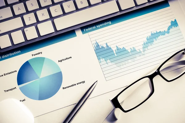 Lugar de trabajo con teclado y diagramas — Foto de Stock