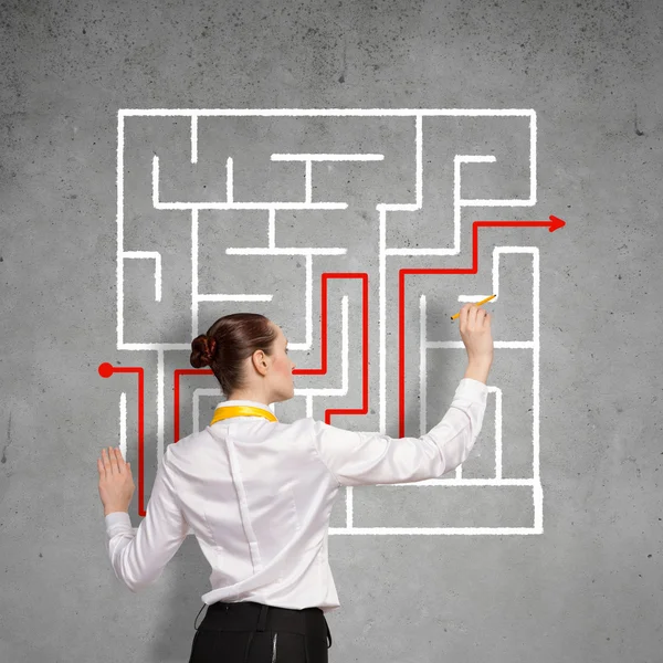 Businesswoman drawing labyrinth — Stock Photo, Image