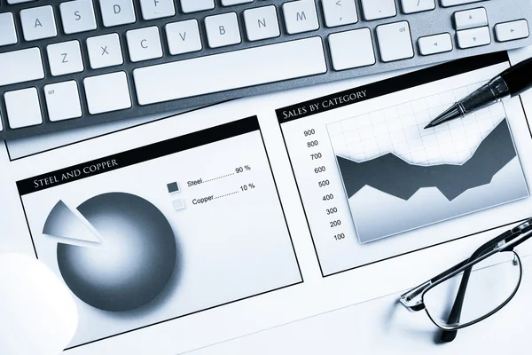 Lugar de trabajo con teclado y diagramas — Foto de Stock