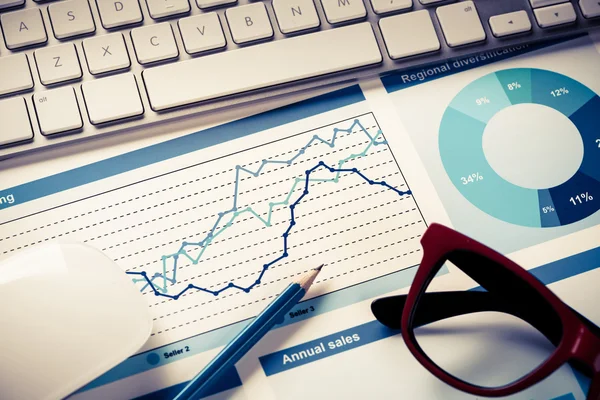 Lugar de trabajo con teclado y diagramas — Foto de Stock