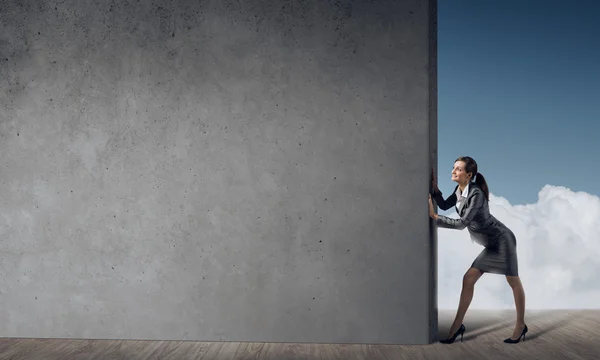 Businesswoman with cement wall — Stock Photo, Image