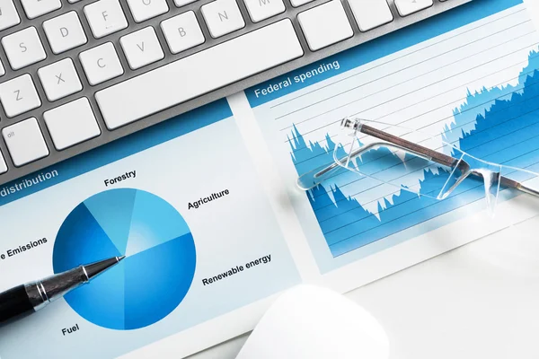 Lugar de trabajo con teclado y diagramas — Foto de Stock