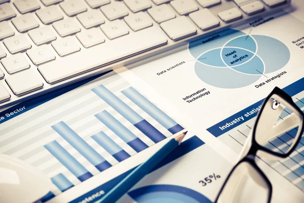 Lugar de trabajo con teclado y diagramas —  Fotos de Stock