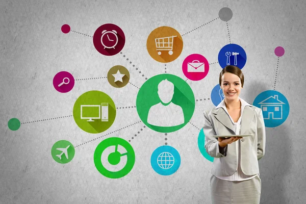 Businesswoman presenting tablet pc and color icons — Stock Photo, Image