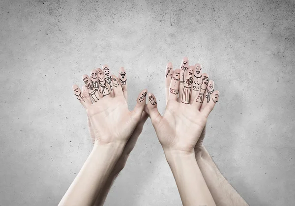 Händer med ansikten på fingrarna — Stockfoto