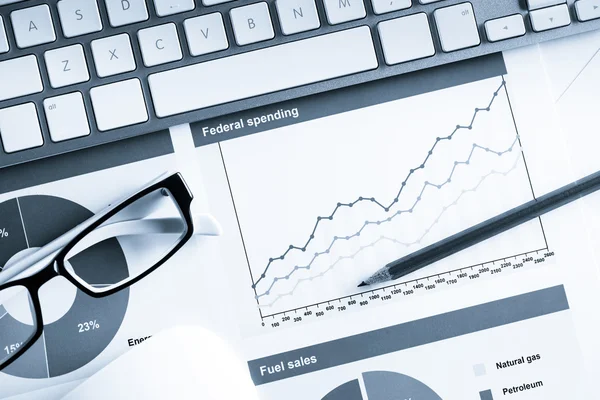 Lugar de trabajo con teclado y diagramas — Foto de Stock