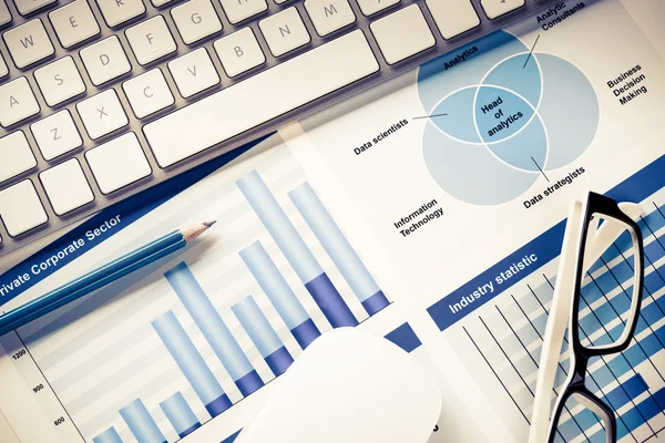 Lugar de trabajo con teclado y diagramas — Foto de Stock