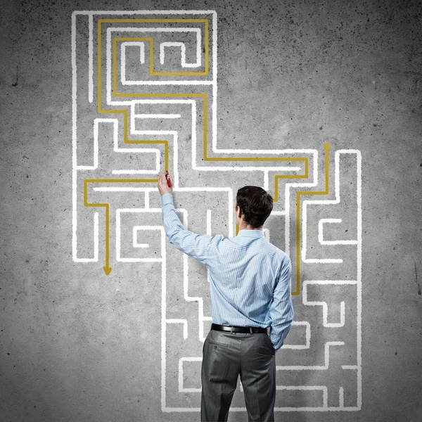 Businessman drawing labyrinth on wall — Stock Photo, Image