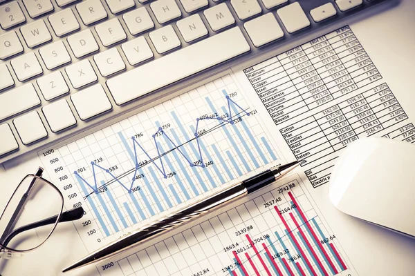 Lugar de trabajo con teclado y diagramas —  Fotos de Stock