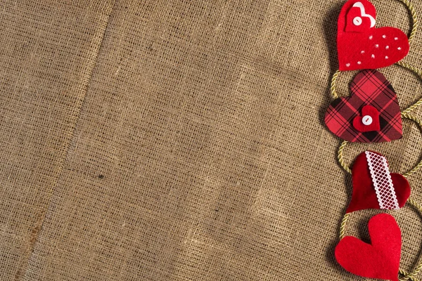 Corazones de amor hechos a mano en la ropa marrón — Foto de Stock