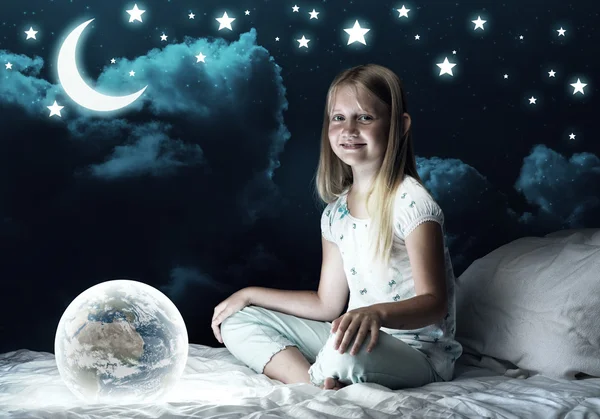 Ragazza nel suo letto e globo incandescente — Foto Stock