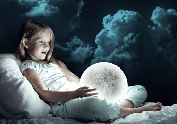 Flicka i hennes säng och måne planet — Stockfoto
