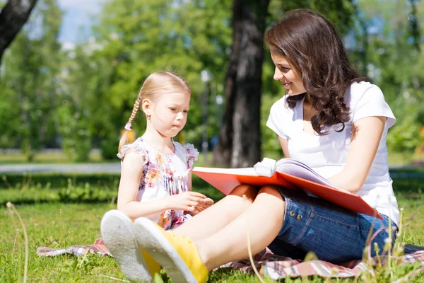 Girl with teacher reading a book — Stock Photo, Image