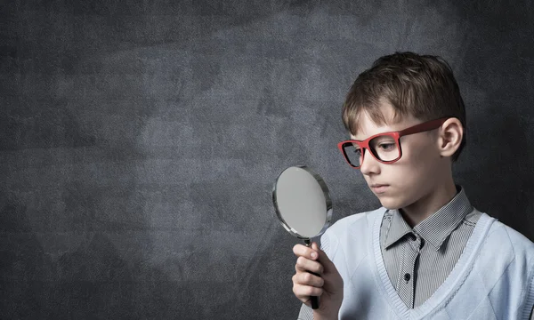 拡大鏡を好奇心が強い学校少年 — ストック写真
