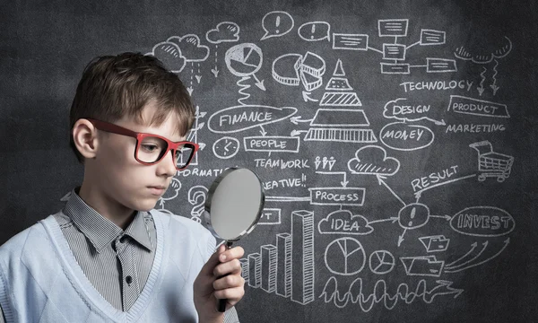 Curioso ragazzo della scuola con lente d'ingrandimento — Foto Stock