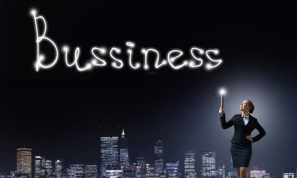 Mujer de negocios con linterna dibuja negocio palabra — Foto de Stock