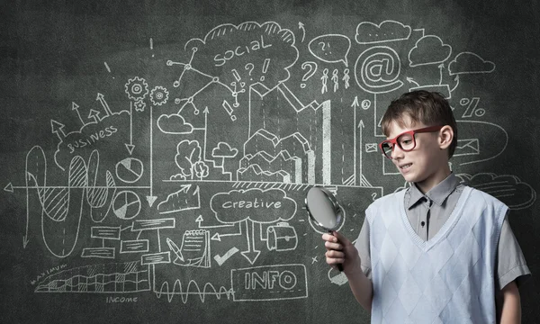 Curioso ragazzo della scuola con lente d'ingrandimento — Foto Stock