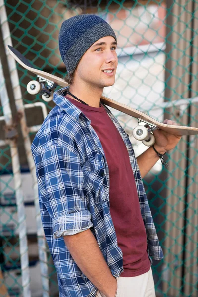 Schöner Kerl mit Skateboard — Stockfoto