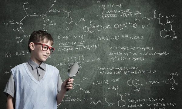 Curious school boy with magnifier — Stock Photo, Image