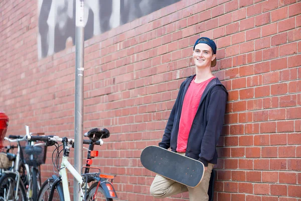Schöner Kerl mit Skateboard — Stockfoto