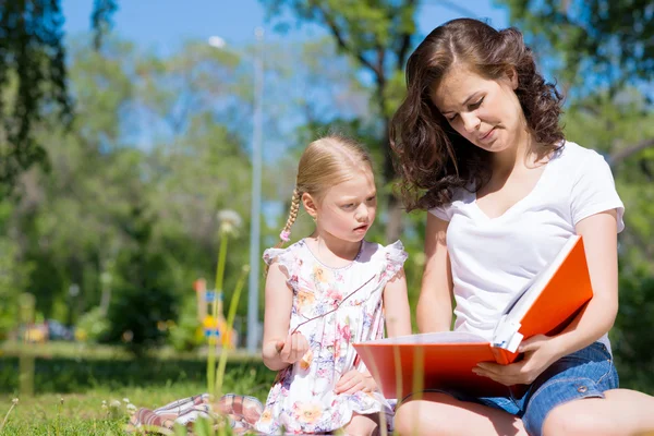 Fille avec professeur lecture livre — Photo