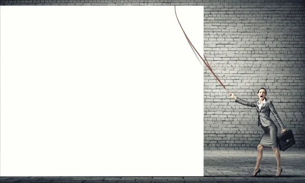 Young businesswoman pulling white banner — Stock Photo, Image