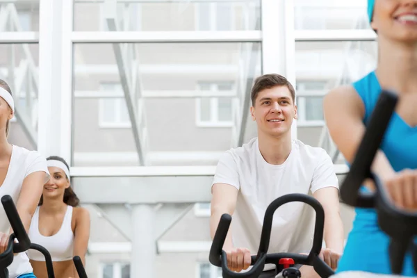 Young people exercising on bikes — Stock Photo, Image