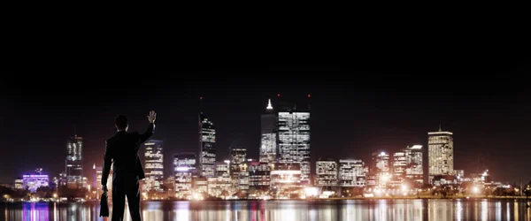 Biznesmen oglądanie miasta świecące w nocy — Zdjęcie stockowe