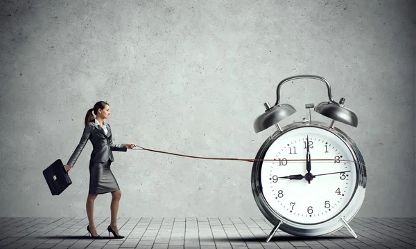 Elegant businesswoman holding alarm clock — Stockfoto