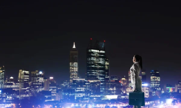 Vrouw kijken naar nacht stad — Stockfoto