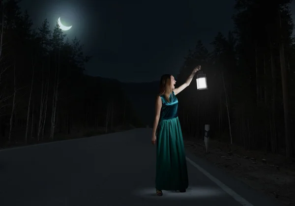 Žena s lucernou kráčí ve tmě — Stock fotografie
