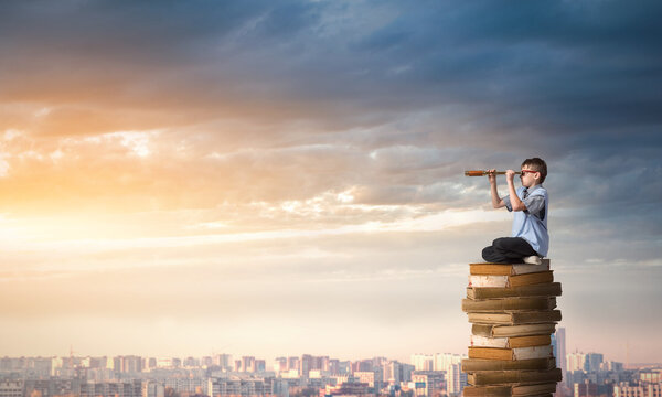 Kid sitting on pile of books