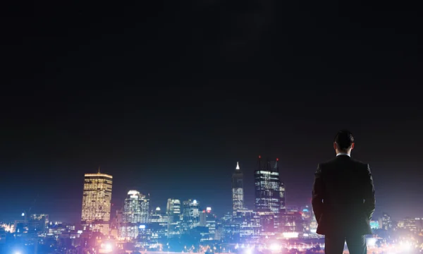 Gece parlayan city ile ilgilenen iş adamı — Stok fotoğraf