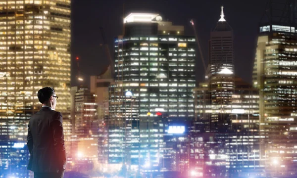 Geschäftsmann sieht Nacht glühende Stadt — Stockfoto