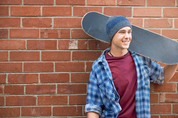 Schöner Kerl mit Skateboard — Stockfoto