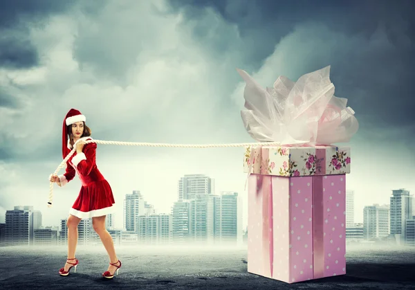 Santa woman pulling gift box — Stock Photo, Image