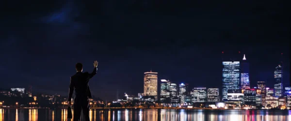 Gece parlayan city ile ilgilenen iş adamı — Stok fotoğraf