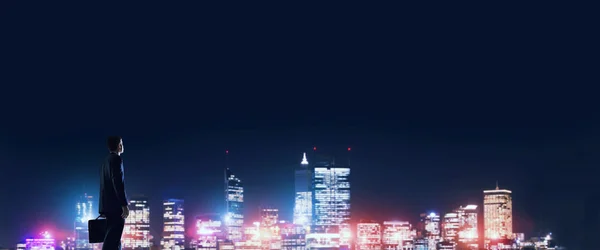 นักธุรกิจดูกลางคืนเมืองที่ส่องแสง — ภาพถ่ายสต็อก