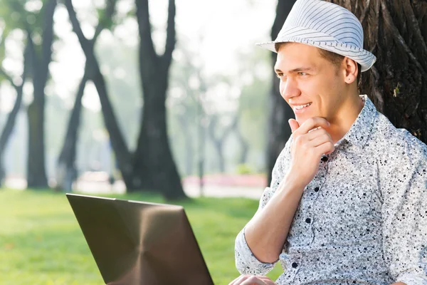 Jeune homme travaillant dans le parc — Photo