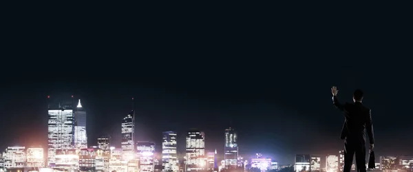 Empresario viendo la noche brillante ciudad — Foto de Stock