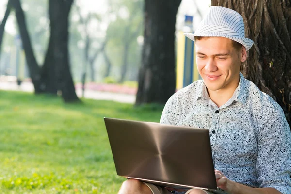 Jeune homme travaillant dans le parc — Photo